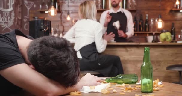 Drunk custumer duerme en una mesa sucia de madera — Vídeos de Stock