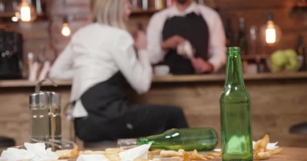 Bouteille de bière vide sur une table sale dans un bar fermé — Video