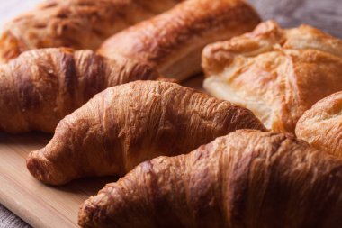 Ahşap kesme tahtası üzerinde çeşitli taze pişmiş hamur işleri