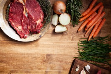 Vintage altın plaka üzerinde çiğ et yanında taze sebze