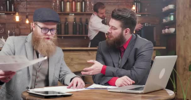 Фрилансеры в красивых костюмах и бородах согласовывают отчеты компании — стоковое видео