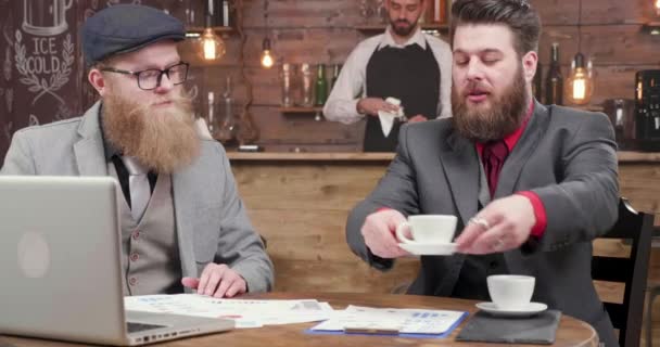 Бородатый бизнесмен подает кофе своему коллеге во время кофе-брейка — стоковое видео
