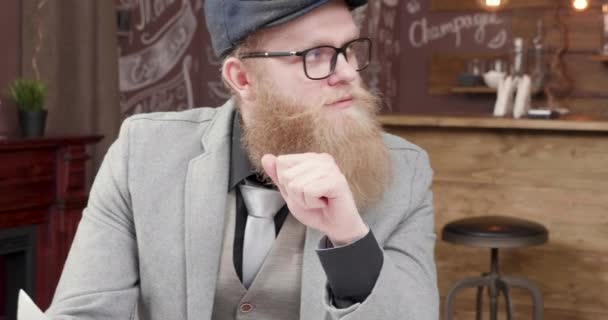 Jovem elegante e bonito com uma bela barba conversa com seu parceiro de negócios — Vídeo de Stock