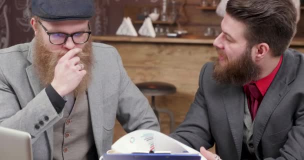 Two stylish males enjoy coffee during a business meeting — Stock Video