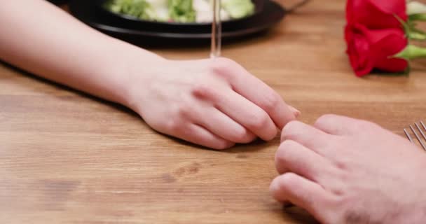 Toque doce de um macho e mãos femininas na mesa de madeira — Vídeo de Stock