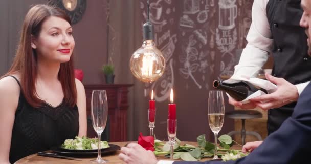 Gülümser ve genç bayan görüşmeler sırasında boş bir bardak şampanya dökme — Stok video