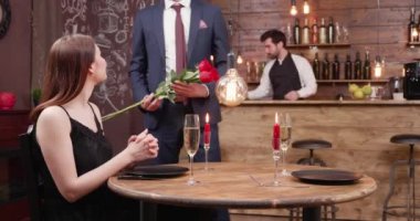 Genç adam bir tarihte geç ve kızına gül sunar