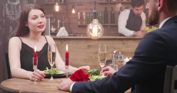 Молодая пара на свидании, щурящая бокалами и пьющая шампанское — стоковое видео