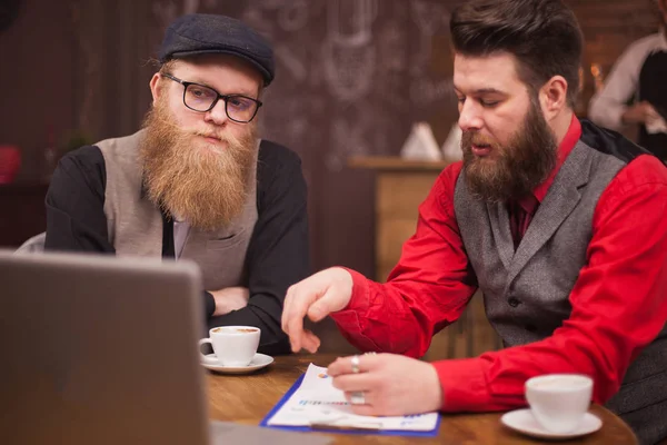 Handsome bearded men having business video call on their laptop in a coffee shop — Stock Photo, Image