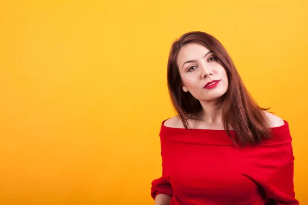 Preciosa joven de unos 20 años mirando a la cámara sobre un fondo amarillo — Foto de Stock