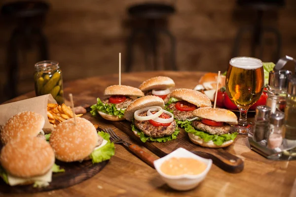 Muitos hambúrgueres deliciosos deitados em uma mesa — Fotografia de Stock