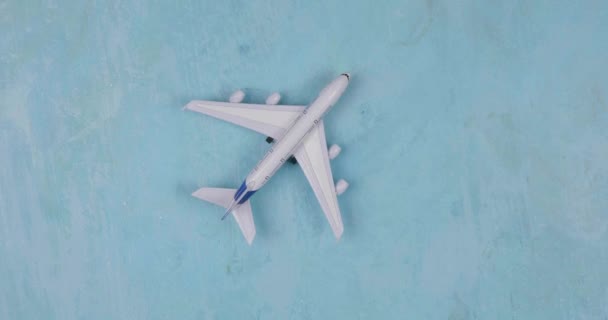 Spielzeugflugzeug auf blauem Hintergrund. Reisestil — Stockvideo