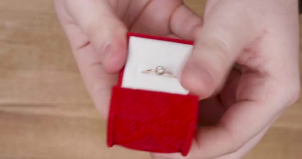 Hands of a male opening a wedding ring box before proposal — Stock Video