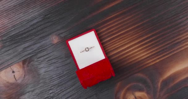 Anello di fidanzamento in cassa rossa su fondo vintage in legno — Video Stock