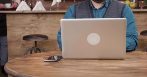 Ober van een coffeeshop brengt een kopje koffie en zet het op de tafel — Stockvideo