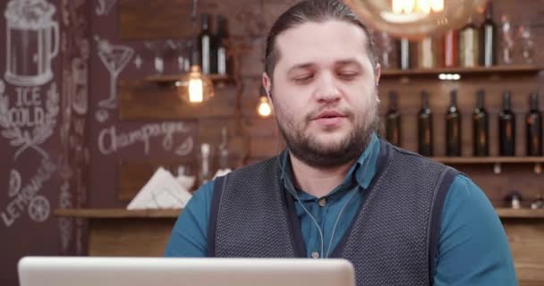 그의 노트북에 즐거운 대화를 나누는 매력적인 남자 — 비디오