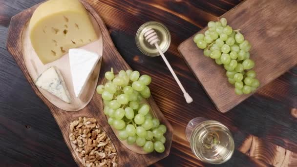 Brie, gouda e queijo roquefort em uma bela composição com vinho branco — Vídeo de Stock