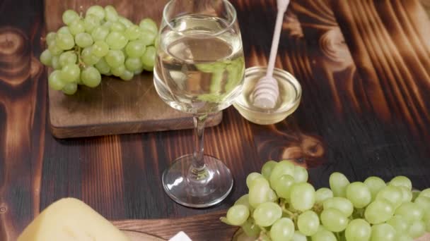 Sklenka bílého vína záběr shora na dřevěné pozadí — Stock video