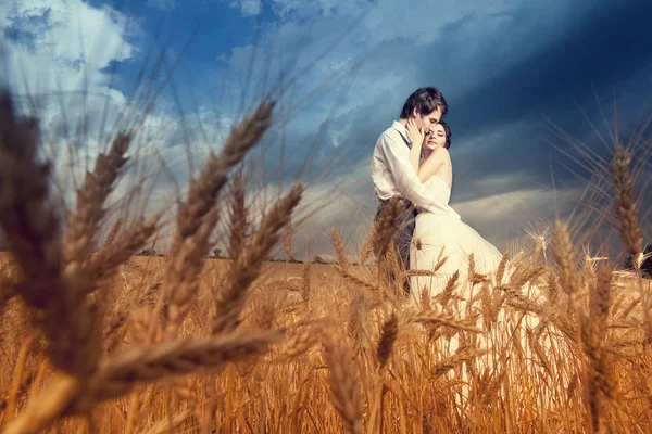 Novia joven y novio en campo de trigo con cielo azul — Foto de Stock