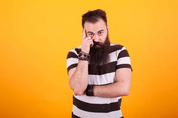 Hipster barbu jeune homme réfléchissant sur fond jaune — Photo