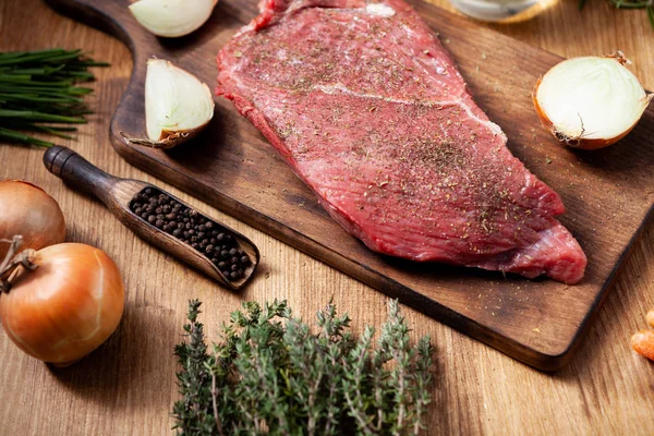 Großes rohes Fleisch auf Schneidebrett mit Rosmarin. — Stockfoto