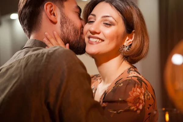 Schöner junger Mann küsst seine Freundin sanft auf die Wange in einer Vintage-Kneipe — Stockfoto