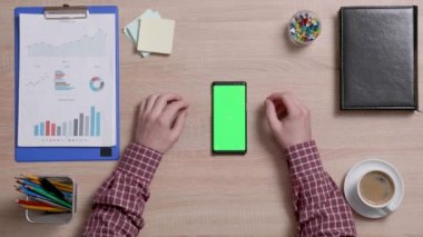 Erkek el üzerinde bir akıllı telefon ile yeşil perde sağ kenarındaki kaydırma Üstten Görünüm