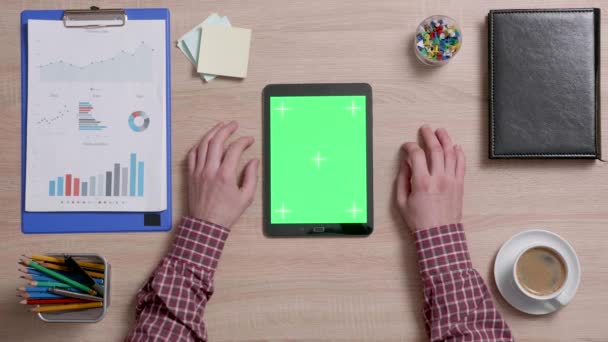 Draufsicht eines Mannes tippt mehrmals auf die Mitte eines grünen Bildschirms auf dem Tablet — Stockvideo
