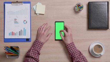 Erkek parmak ve bir akıllı telefon yeşil bir ekran yakınlaştırma Üstten Görünüm