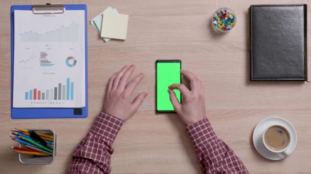 Vue du dessus des doigts masculins zoomant sur un écran vert d'un téléphone intelligent — Video