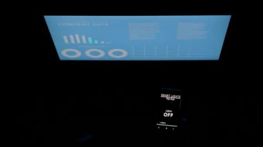 Bir ofiste ses aktive uzaktan ışık kontrol uygulaması kullanan adam