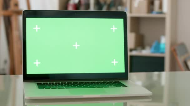 Ordenador portátil con pantalla verde en un escritorio de oficina de vidrio — Vídeos de Stock