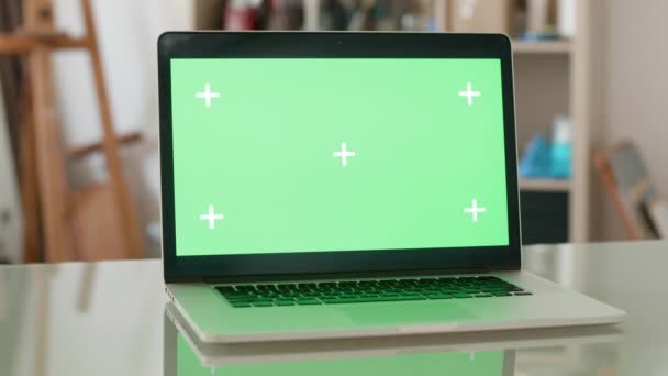 Paralaje de un ordenador portátil con tornillo verde y la gente en el fondo — Vídeos de Stock
