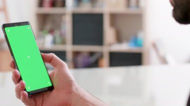 Adam sağ elinde gren ekran ile bir akıllı telefon tutar