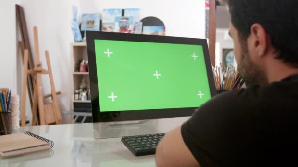 Brodaty mężczyzna patrząc na zielony ekran na swoim komputerze — Wideo stockowe