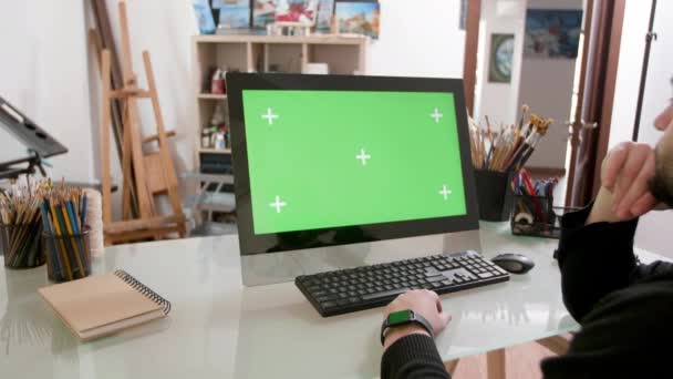 Bearded man with artistic look watches a video on a green screen — Stock Video