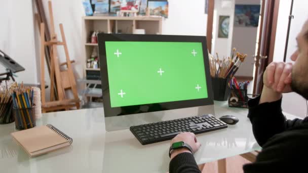 Man gericht op een groen scherm in een workshop voor schilders — Stockvideo
