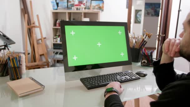 Man focused on a green screen in a painters workshop — Stock Video