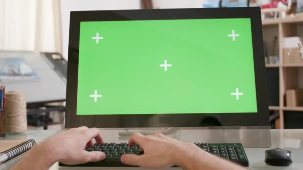 Мужские руки, печатающие на клавиатуре перед зеленым экраном — стоковое видео