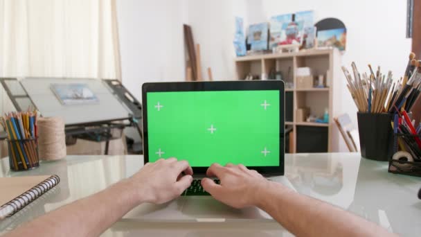 Ontwerpers oogpunt werken op een laptop met groen scherm op — Stockvideo