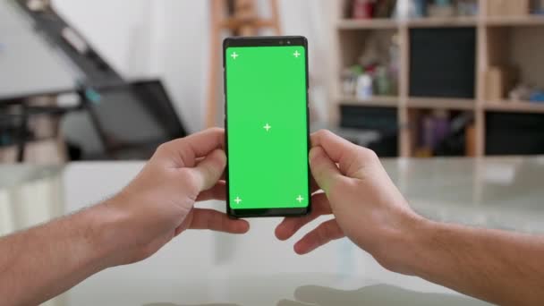 Mans oogpunt een smartphone verticaal met groen scherm op te houden — Stockvideo