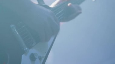 Müzisyen eller bir rock konserinde bir kalabalığın önünde bir gitar oynar