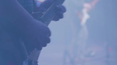 Erkek müzisyen eller bir rock konseri bir kalabalığın önünde bir gitar oynar