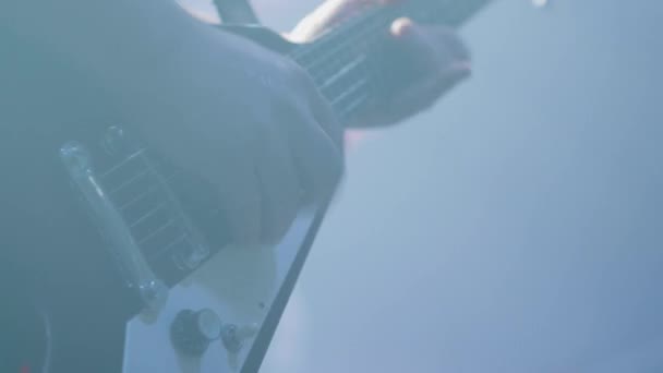 Τα χέρια των μουσικών παίζουν σε μια κιθάρα μπροστά σε ένα πλήθος σε μια ροκ συναυλία — Αρχείο Βίντεο