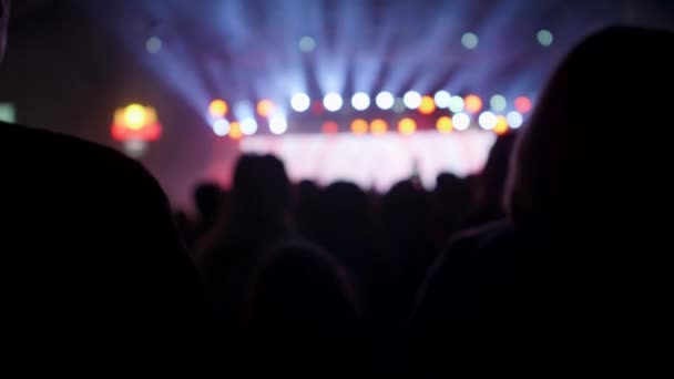 Multitud de personas en un concierto de rock mirando un escenario — Vídeo de stock