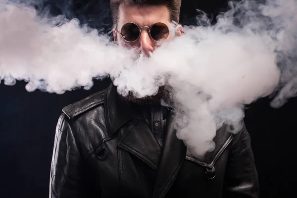 Het roken van sigaretten coming out van knappe baard man neus over zwarte achtergrond — Stockfoto