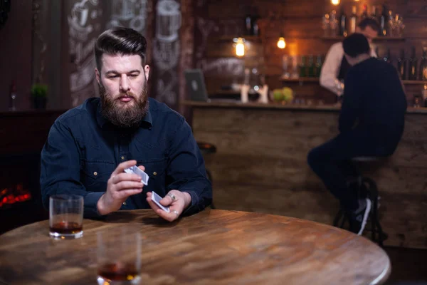 Guapo barbudo perdido en sus pensamientos junto a un vaso de whisky —  Fotos de Stock