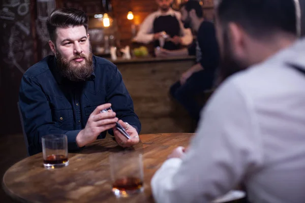 Atractivos hombres barbudos bebiendo whisky en un pub —  Fotos de Stock