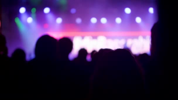 Jóvenes en un evento de música frente a un hermoso escenario iluminado — Vídeo de stock