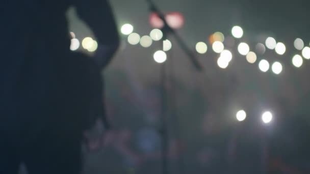 Musicien performant devant les fans tenant des lampes de poche smartphone 